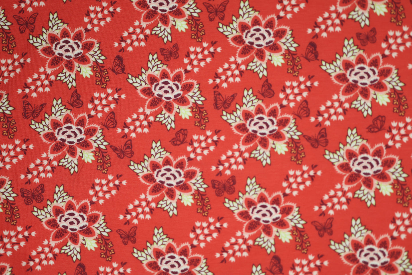 Baumwollstoff mit Motiv: florales muster mit schmetterlingen in rot – weich & kindgerecht.