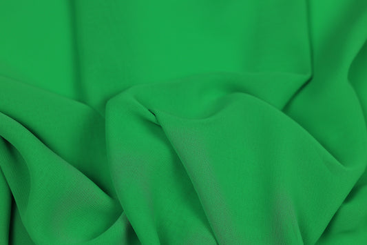 Grüner fließender Chiffonstoff mit elegantem Faltenwurf – ideal für Kleider und Blusen