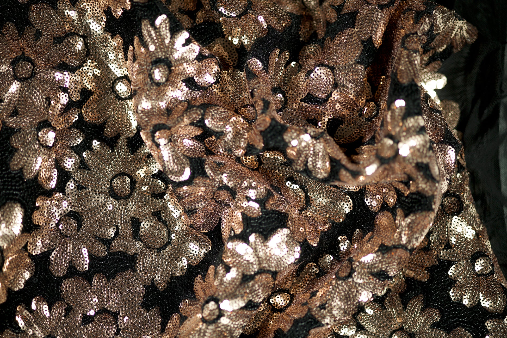 Detailaufnahme von schwarzem Tüllstoff mit Roségold-Pailletten in Blumenmuster – ideal für Abendmode