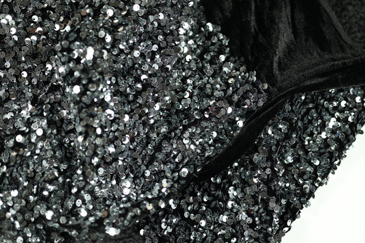 Glänzender Paillettenstoff in Silber auf schwarzem Samt – ideal für Abendmode