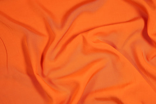 Viskosestoff in Signalorange mit fließendem Fall – perfekt für Sommermode