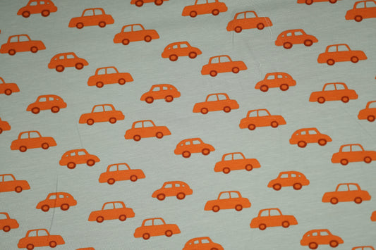 Kinderstoff aus Baumwolle mit orangen Autos auf hellgrauem Hintergrund.