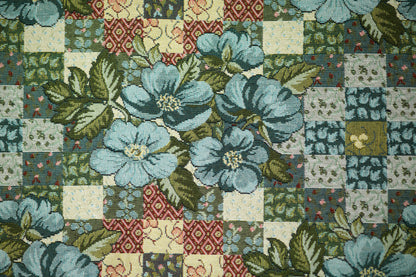 Bunter Möbelstoff mit Patchwork-Optik und blauen Blumen auf hellem Grund – perfekt für kreative Polsterprojekte