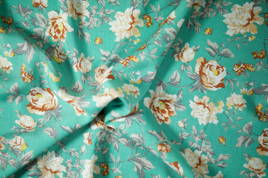 Sommerlicher Stoff mit floralen Elementen auf Türkis