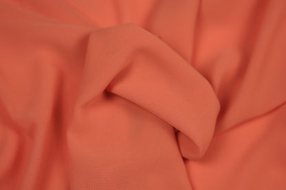 Detailaufnahme von Chiffonstoff in Koralle – halbtransparent und edel fallend