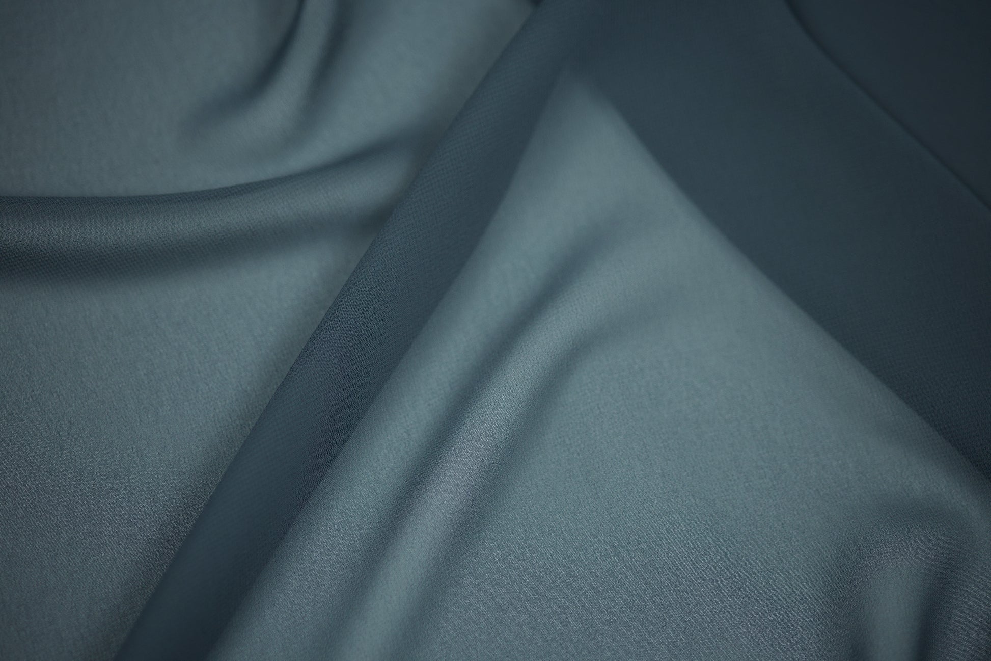 Detailaufnahme von Chiffonstoff in Dunkelpetrol – leicht transparent und edel fallend